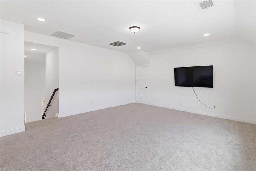 Carpeted room with recessed lighting and a ceiling-mounted fixture