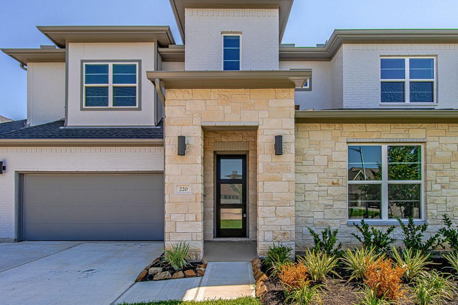 Closer view of the covered front entry and modern brick-and-stucco exterior