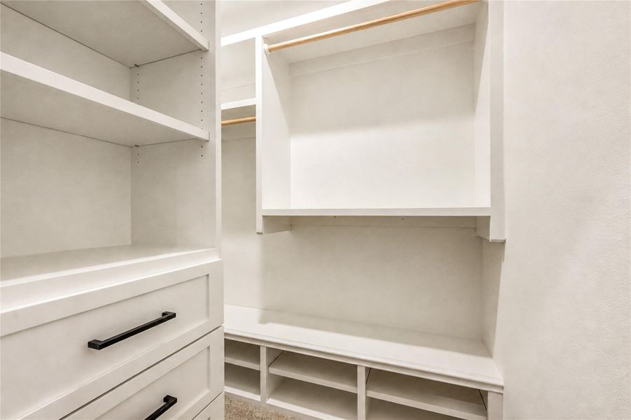 Spacious walk-in closet for the 2nd bedroom, with built-in shelving and drawers, offering ample storage and organization options.