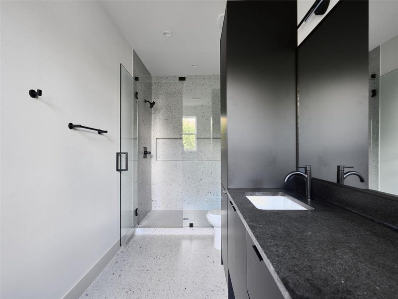 Full bathroom with vanity, dark speckled floor, and a shower stall Full bathroom with vanity, dark speckled floor, and a shower stall