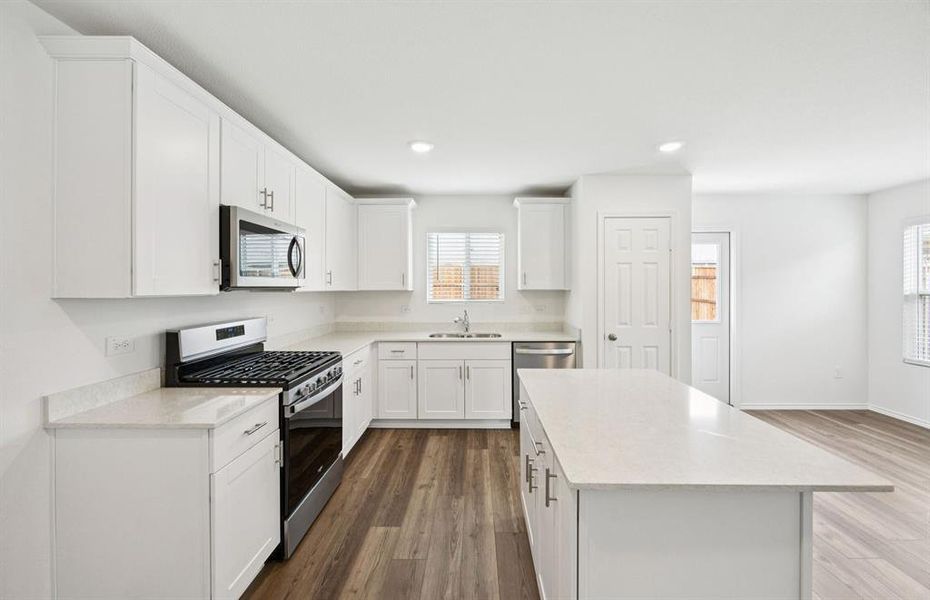 Large island overlooking gathering room and dining areas