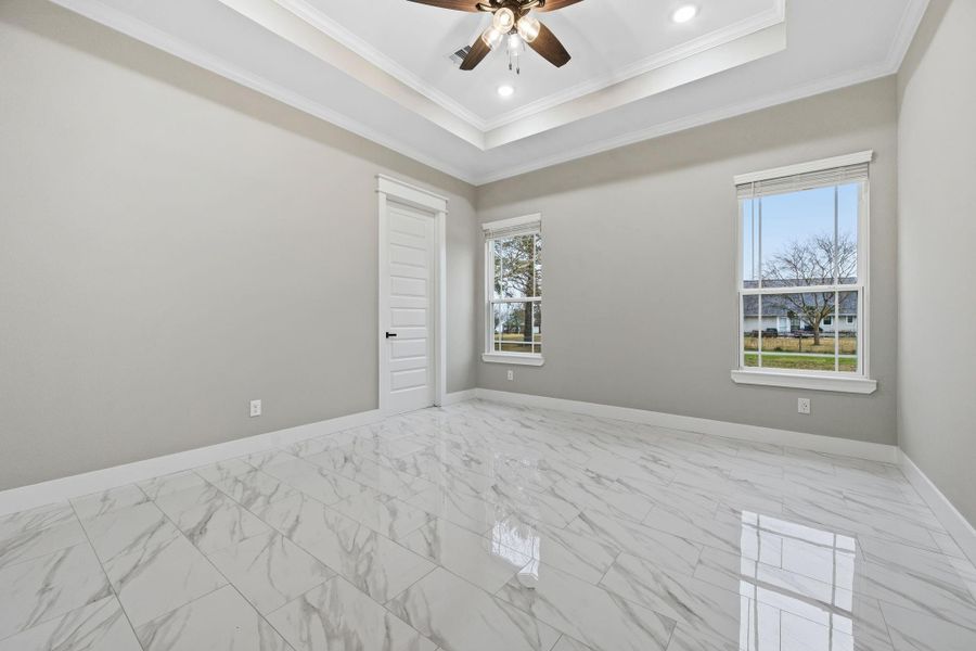 Primary bedroom with beautiful trayed ceiling, crown molding and en-suite bath. Primary bedroom with beautiful trayed ceiling, crown molding and en-suite bath.