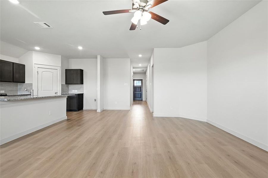Unfurnished living room with ceiling fan, recessed lighting, and light wood-type flooring