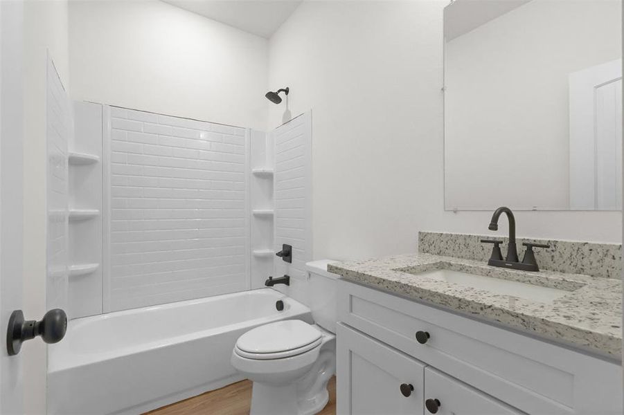 Full bathroom with shower / bath combination, toilet, vanity, and hardwood / wood-style floors