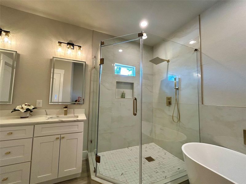 Gold colored fixtures in the primary bathroom. Gold colored fixtures in the primary bathroom.