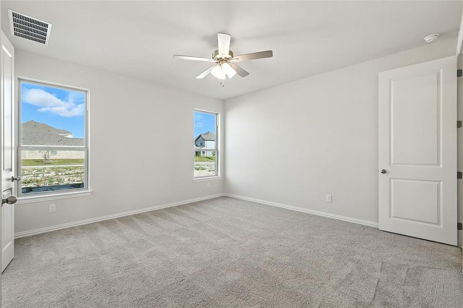Spare room featuring light carpet and a ceiling fan Spare room featuring light carpet and a ceiling fan