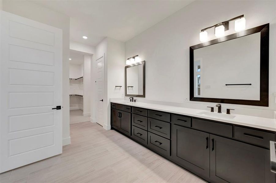 Owners bath featuring double vanity, recessed lighting, and light wood-style flooring