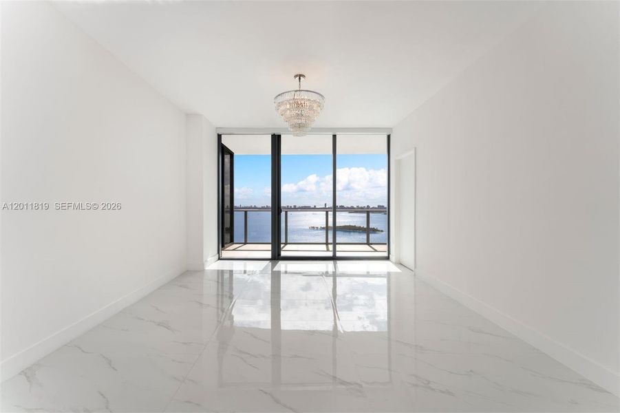Serene primary suite offering unobstructed water views, direct terrace access, oversized walk-in closets, and floor-to-ceiling windows for a true 'mansion in the sky' feel.