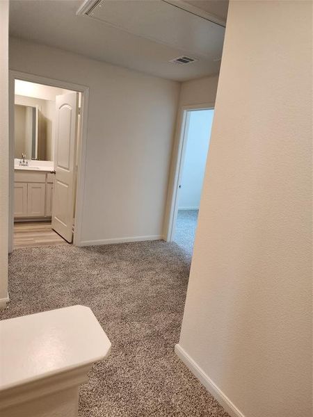 Corridor with light carpet and attic access Corridor with light carpet and attic access