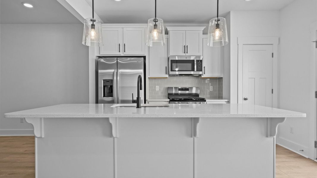 First-class kitchen with a spacious 9-foot island—perfect for entertaining beneath designer pendant lighting First-class kitchen with a spacious 9-foot island—perfect for entertaining beneath designer pendant lighting