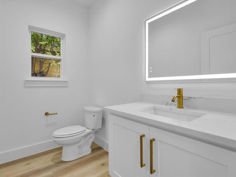 Bathroom featuring vanity, toilet, and wood-type flooring