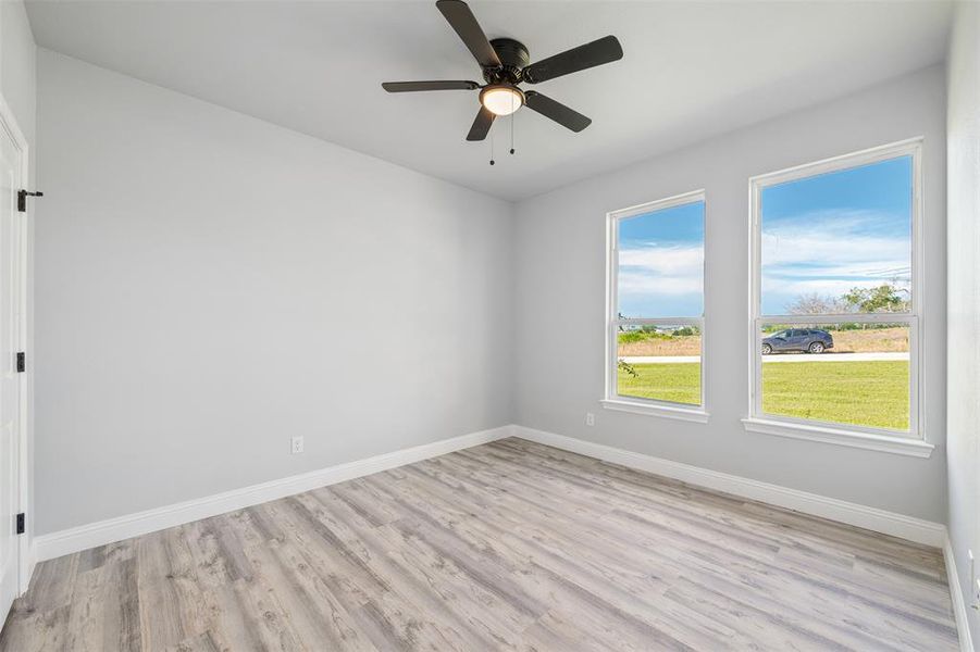 Empty room with light wood-style floors and ceiling fan Empty room with light wood-style floors and ceiling fan