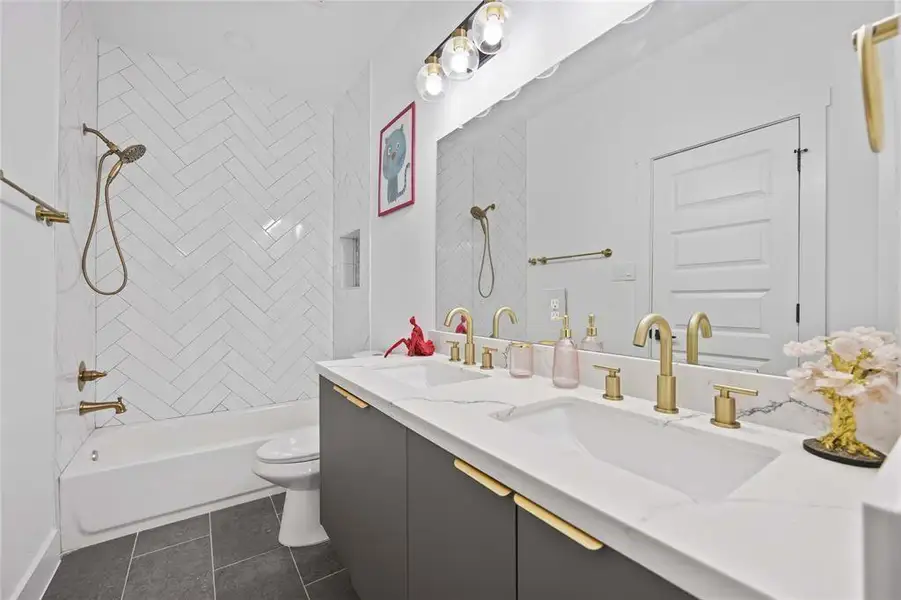 The third full bath features dual sinks, an oversized mirror, gorgeous quartz countertops and a fully tiled bath. Simply beautiful!