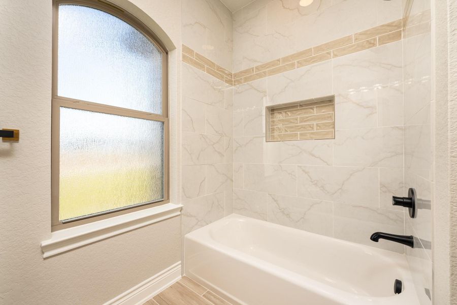 Full bathroom featuring washtub / shower combination, a textured wall, and wood tiled floors Full bathroom featuring washtub / shower combination, a textured wall, and wood tiled floors