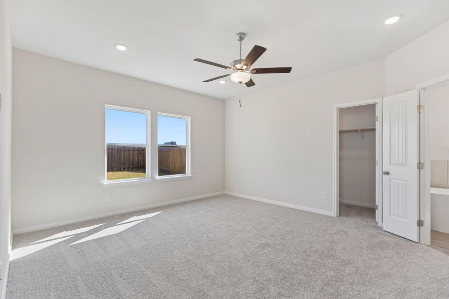 Plush carpeting and dual windows illuminate this airy bedroom retreat.