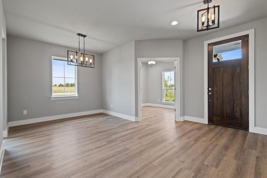 Foyer entrance with an inviting chandelier and light wood-type flooring