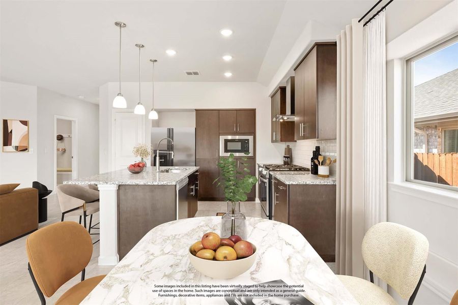 Open-concept kitchen with dark wood cabinets, granite island, pendant lights, and stainless steel appliances, viewed from dining area.