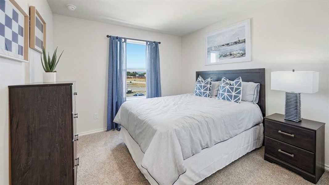 Bedroom featuring light carpet and baseboards Bedroom featuring light carpet and baseboards