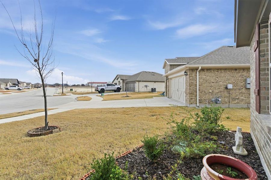 View of yard with a residential view, concrete driveway, and a garage