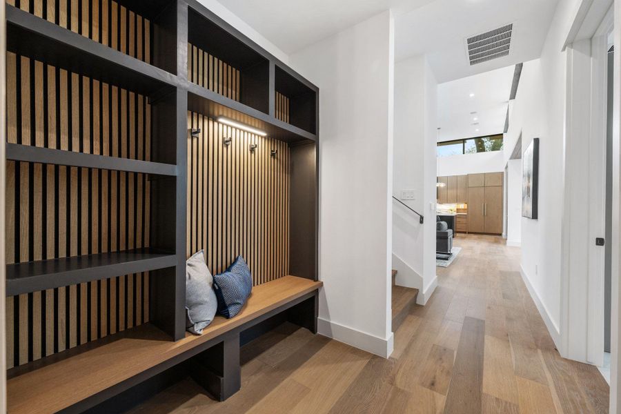 Mudroom with light wood finished floors, recessed lighting, and a high ceiling