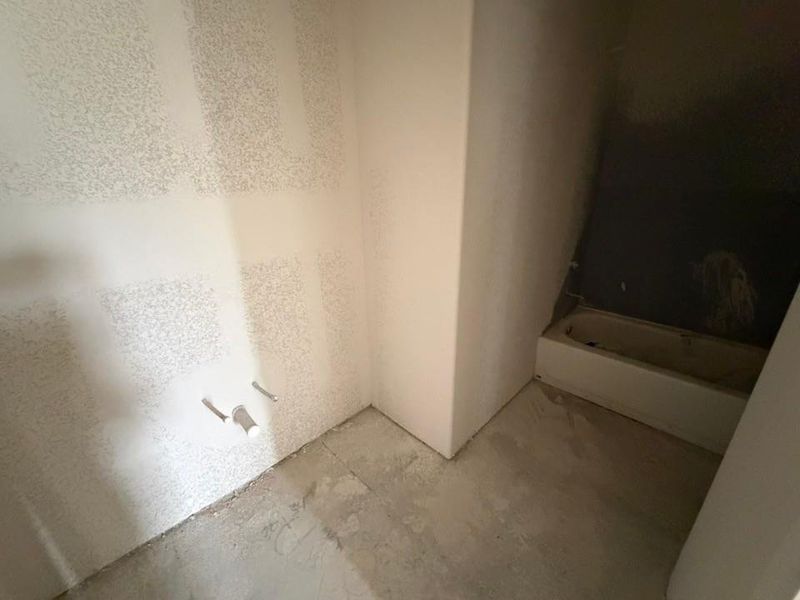 Bathroom featuring concrete flooring and a bathtub Bathroom featuring concrete flooring and a bathtub