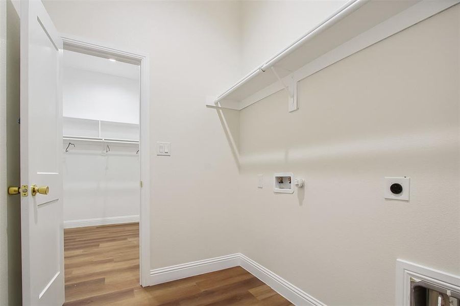 Washroom with hardwood / wood-style flooring, gas dryer hookup, hookup for an electric dryer, and hookup for a washing machine