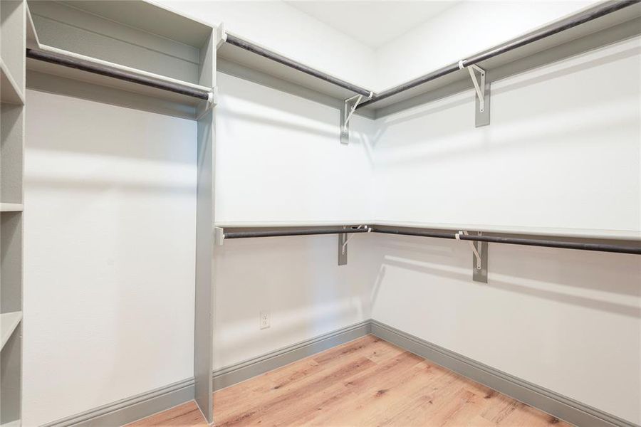 Walk in closet with light wood-style floors