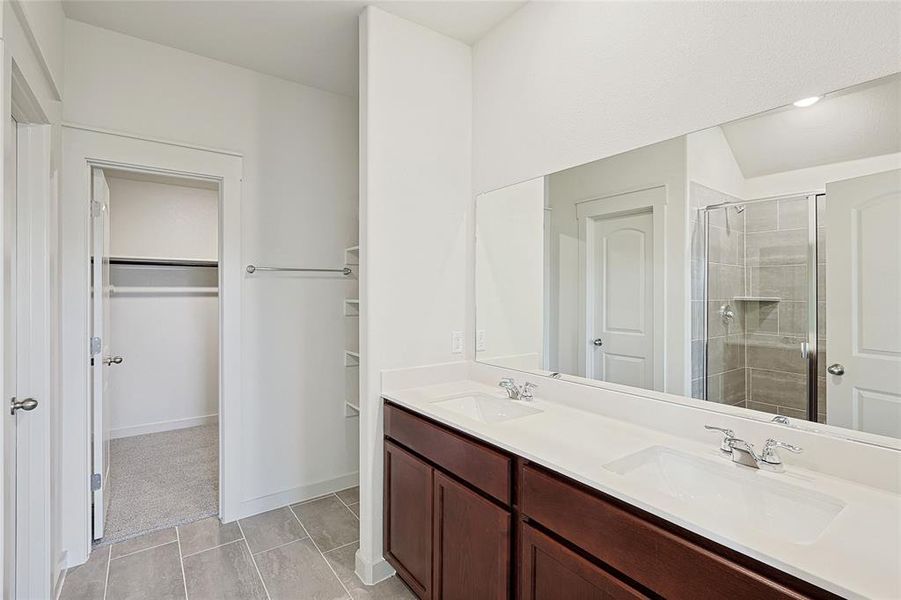 Bathroom featuring vanity and a shower with door