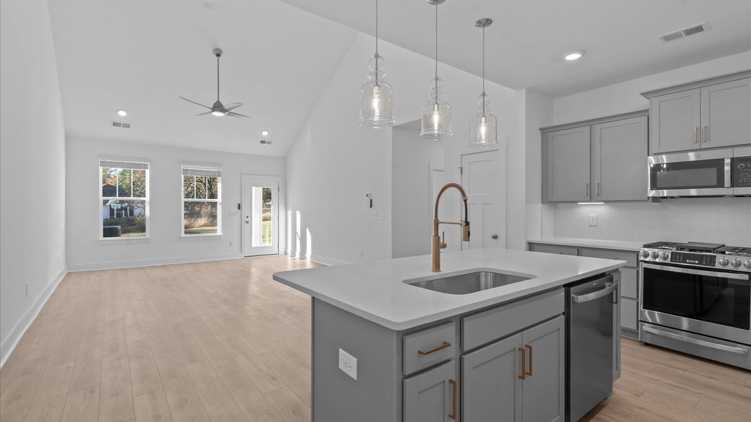 Highly skilled craftsmanship shines in this modern kitchen with pendant lighting and a central island focal point