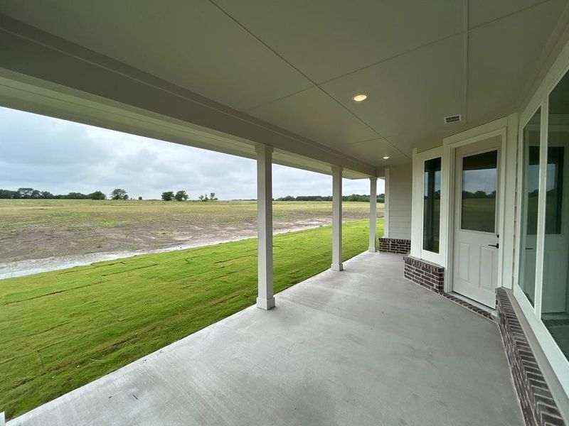 Expansive covered patio featuring a concrete surface, recessed lighting, and white support columns