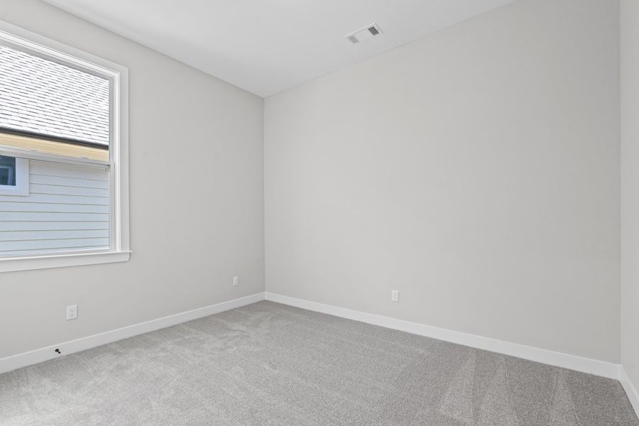 Spare room with light carpet and baseboards Spare room with light carpet and baseboards