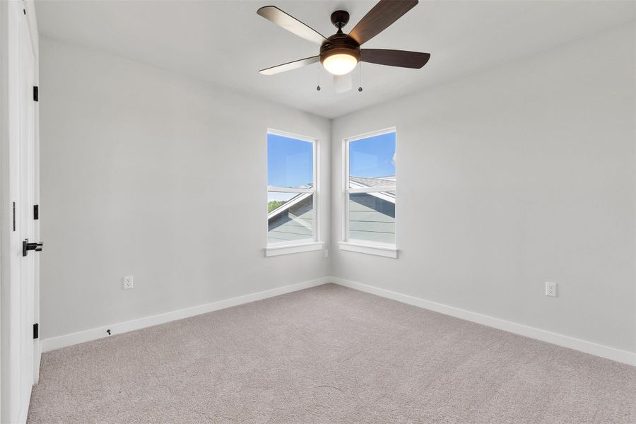 Spare room with light colored carpet and a ceiling fan
