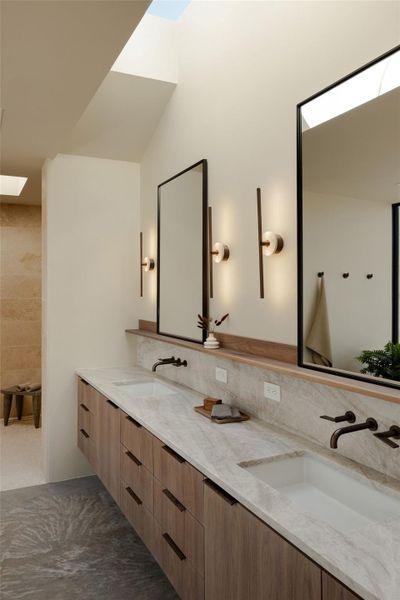 Primary Bathroom with double vanity, a skylight, Taj Mahal leathered Quartzite countertops, generous travertine walk-in shower with skylight, soaking tub, under cabinet lighting.