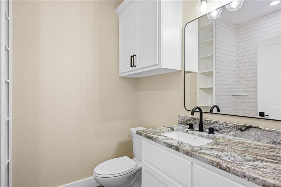 Half bath featuring vanity and toilet Half bath featuring vanity and toilet