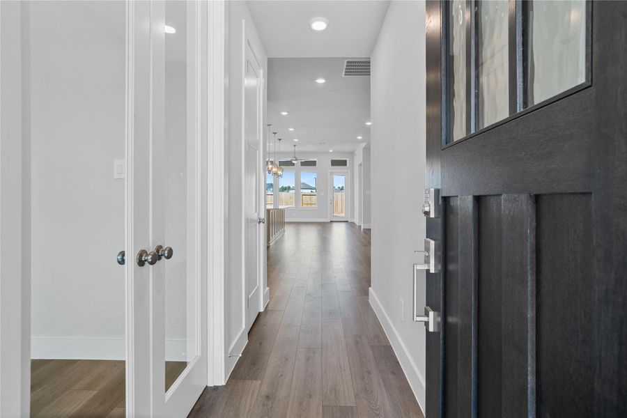 Welcome inside to a bright and inviting entryway that sets the tone for this modern home. Crisp white walls and abundant natural light create an open and spacious feel throughout the hallway. The laminate flooring extends seamlessly through the area, offering both aesthetic appeal and durability.