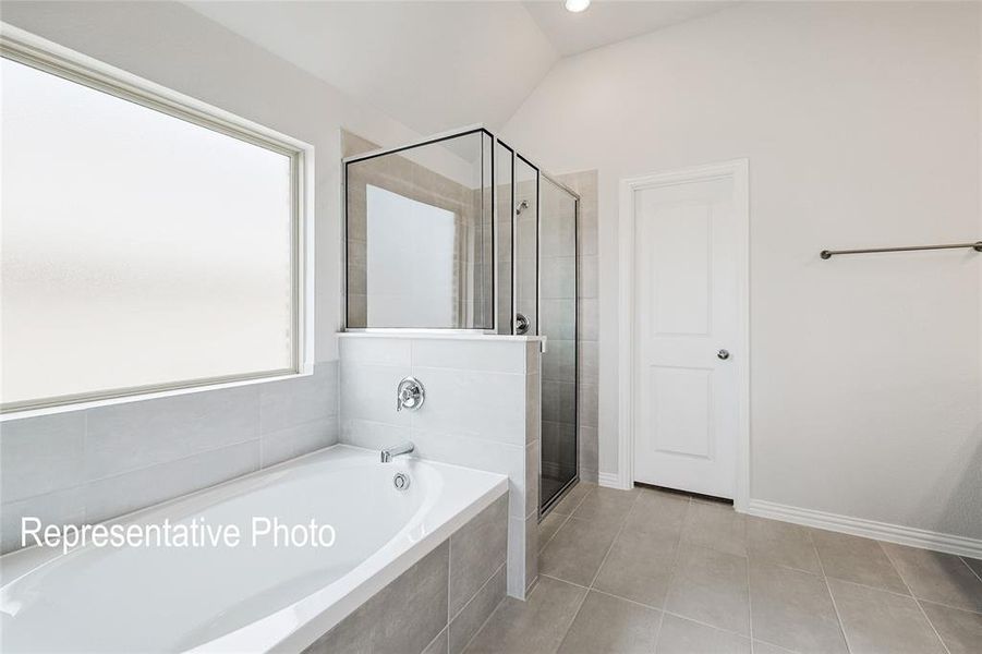 Bathroom with plus walk in shower, tile patterned flooring, and lofted ceiling