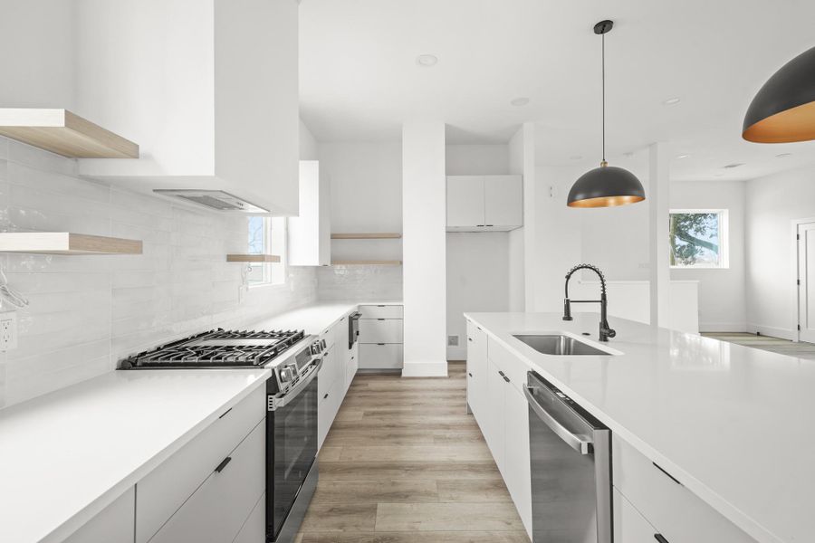 This chef inspired space is equipped with a GE gas range with 4 burners plus a griddle, a microwave tucked into the lower cabinetry and a decorative vent hood. This chef inspired space is equipped with a GE gas range with 4 burners plus a griddle, a microwave tucked into the lower cabinetry and a decorative vent hood.