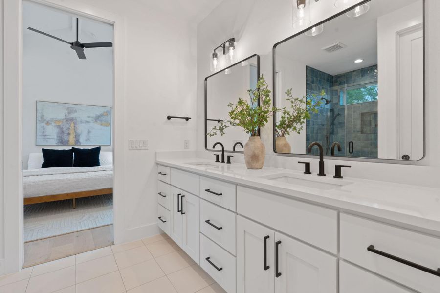 Full bath with a shower stall, double vanity, light tile patterned floors, and a ceiling fan Full bath with a shower stall, double vanity, light tile patterned floors, and a ceiling fan