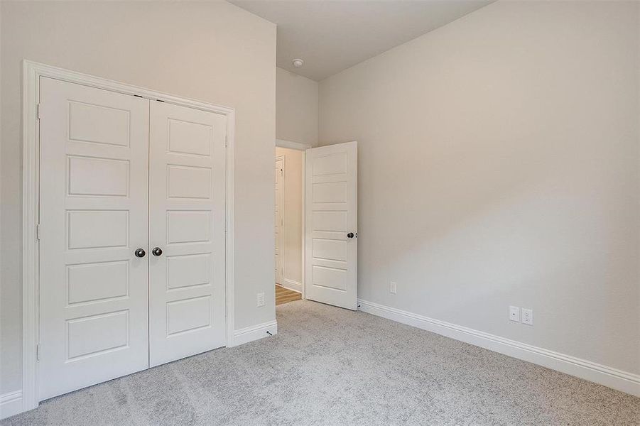 Unfurnished bedroom with a closet and light colored carpet