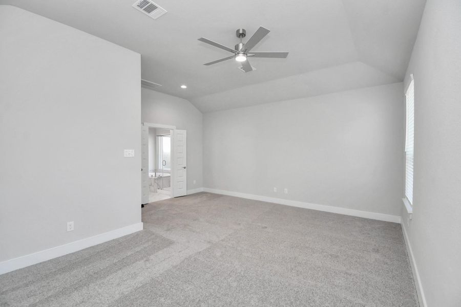 Escape to tranquility in this spacious primary room, adorned with plush carpeting and bathed in the soothing hues of warm paint colors, creating a cozy retreat for relaxation.