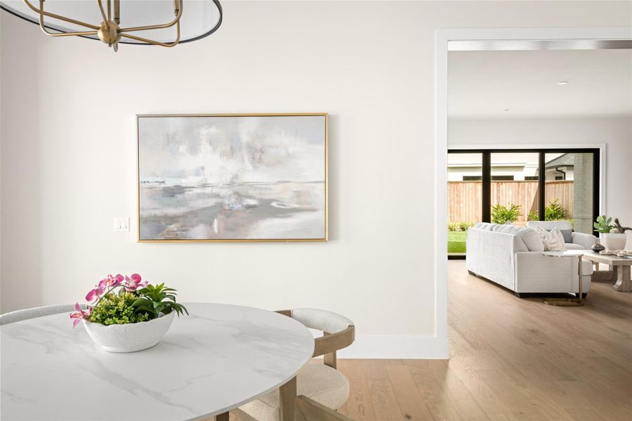 Charming breakfast nook with designer lighting and marble top dining surface, perfectly positioned off the kitchen. Large sliding glass doors fill the space with natural light and create a seamless connection to the living area and backyard. Charming breakfast nook with designer lighting and marble top dining surface, perfectly positioned off the kitchen. Large sliding glass doors fill the space with natural light and create a seamless connection to the living area and backyard.