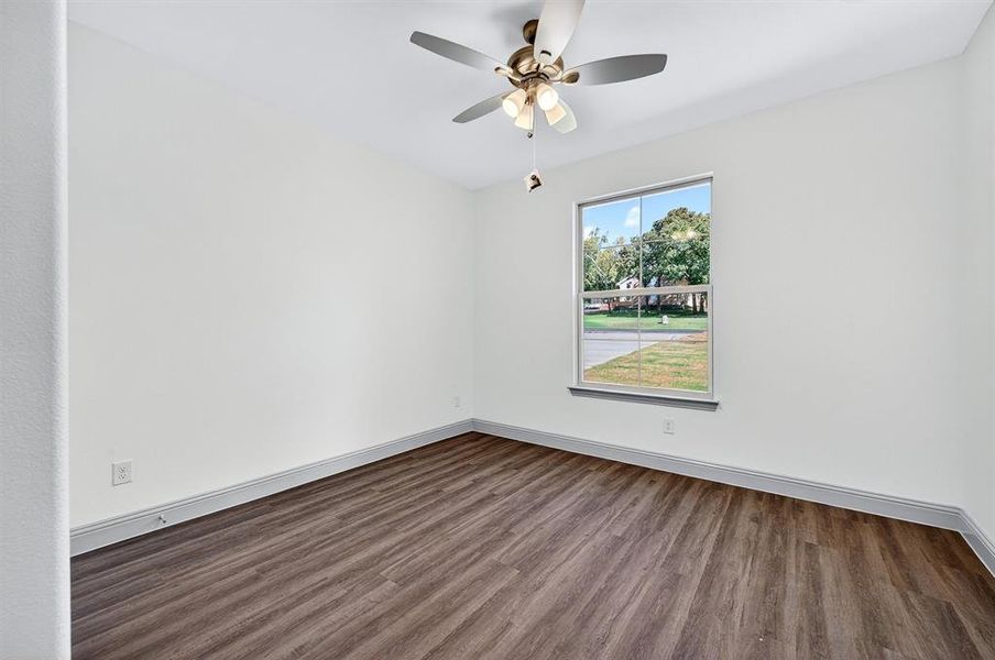Empty room featuring dark wood-style floors and ceiling fan