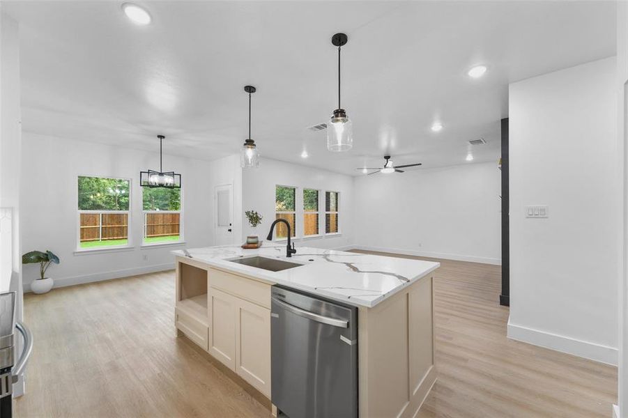 Kitchen island with a waterfall countertop, integrated sink, and stainless steel dishwasher Kitchen island with a waterfall countertop, integrated sink, and stainless steel dishwasher