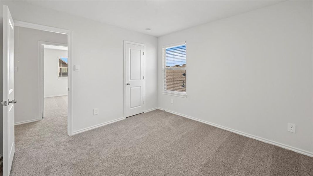 Unfurnished bedroom with carpet flooring and baseboards