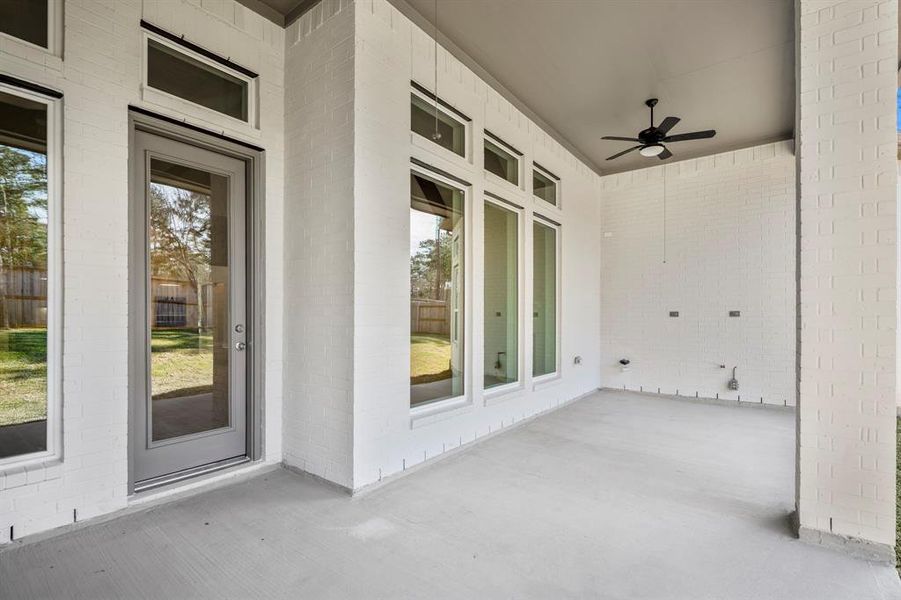 Unwind in this charming covered patio, perfect for year-round relaxation or lively gatherings. Enjoy the seamless indoor-outdoor flow, enhanced by elegant brickwork and large windows brightening your days.