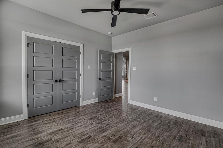 Unfurnished bedroom with ceiling fan and a closet