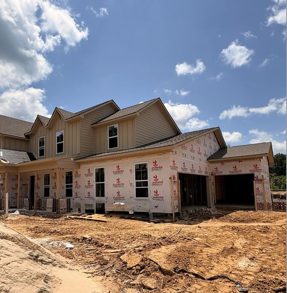 Newly constructed residence featuring a multi-gable roofline, board and batten siding, multiple windows, and an integrated two-car garage Newly constructed residence featuring a multi-gable roofline, board and batten siding, multiple windows, and an integrated two-car garage