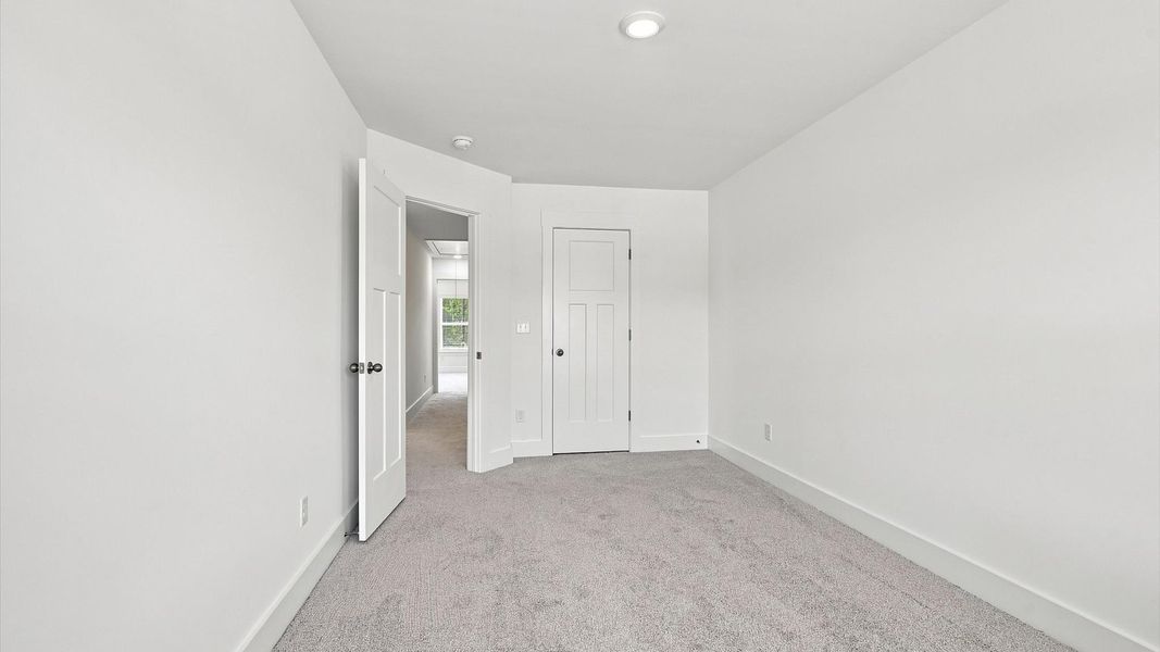 Notable secondary bedroom offering cozy carpeted flooring and a stylish walk-in closet at Barton Hollow Notable secondary bedroom offering cozy carpeted flooring and a stylish walk-in closet at Barton Hollow