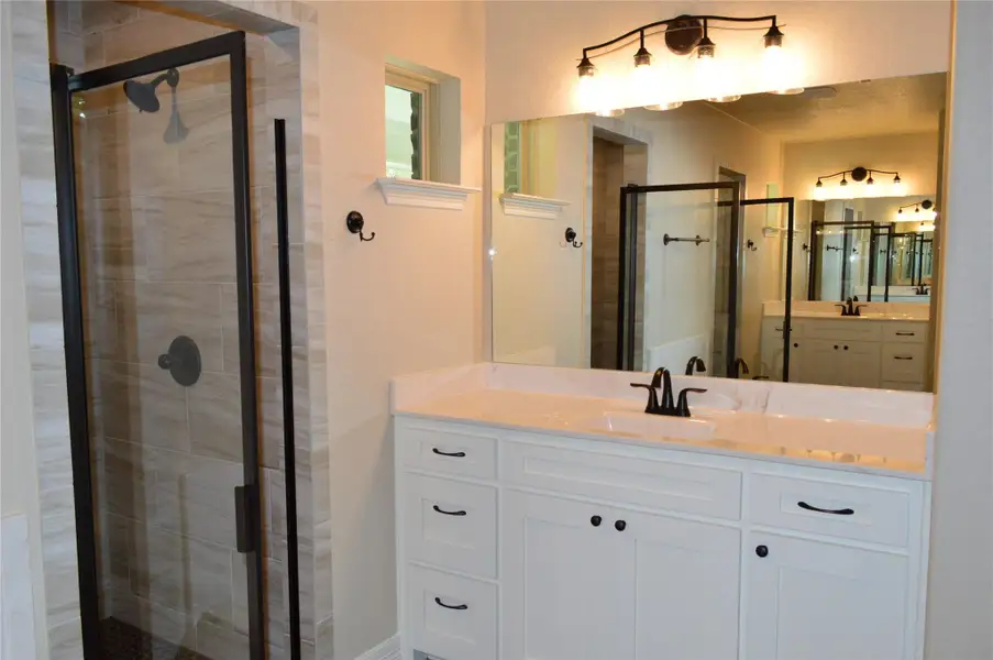 Bathroom featuring a shower stall and vanity