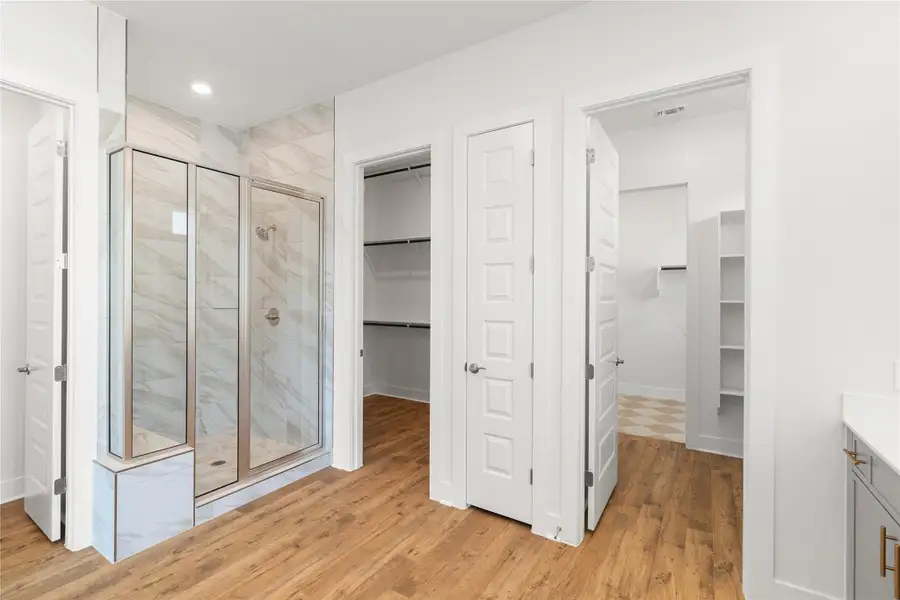 A generous walk-in shower and ample closet space define this well-appointed primary bathroom. A generous walk-in shower and ample closet space define this well-appointed primary bathroom.